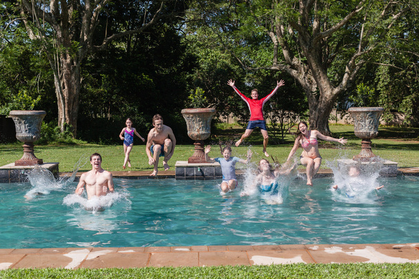 Tytöt pojat hyppäämällä uima-allas
 - Valokuva, kuva