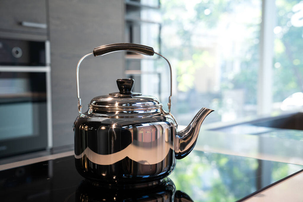 Stainless Water Crow or Vintage Kettle tea pot on electronic stove in modern Kitchen room. - Valokuva, kuva