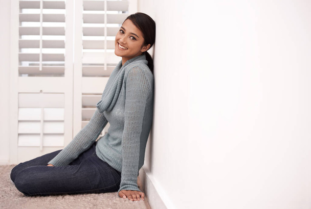 Relaxa no chão do quarto. Retrato de uma jovem mulher encostada à parede enquanto sentada no chão do quarto - Foto, Imagem