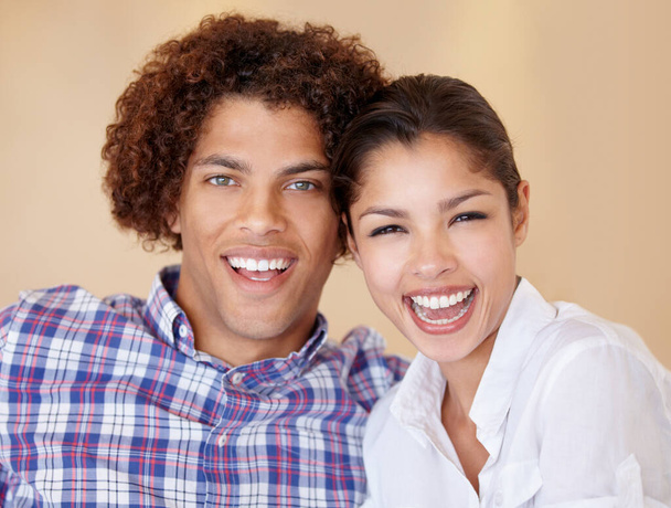 Счастливы вместе. счастливая молодая этническая пара сидит бок о бок и смеется вместе - Фото, изображение