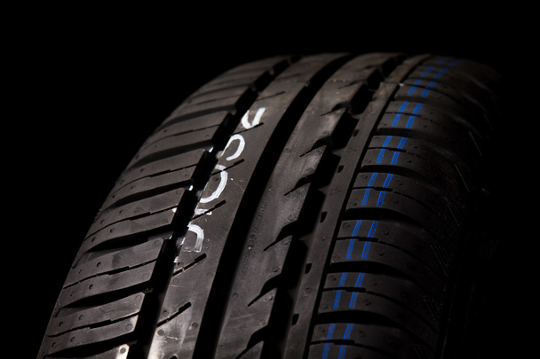 Neumáticos del coche primer plano sobre fondo negro
 - Foto, Imagen