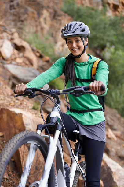 A subir a montanha de bicicleta. Uma mulher bonita morena mountain bike em um cenário cênico - Foto, Imagem
