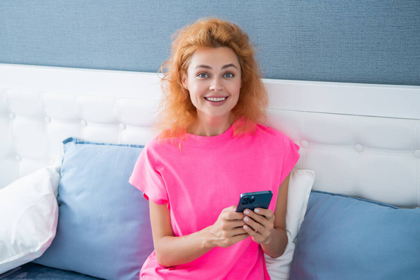 glad girl relax at home and messaging on phone. girl messaging on phone on the bed. phone messaging of girl. - Φωτογραφία, εικόνα