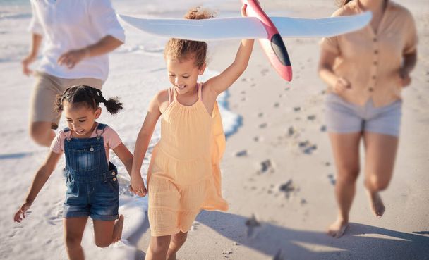 Happy, toys and beach children running, play or have family fun on Costa Rica holiday vacation. Love bond, travel and quality time for kids, sisters or friends with parents on sea water or ocean sand. - Photo, Image