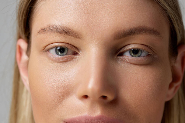 Cropped close-up image of beautiful female eyes, perfect smooth skin, natural make up. Concept of beauty, smooth skin, cosmetology, spa, plastic sugery. Copy space for ad - Foto, Bild