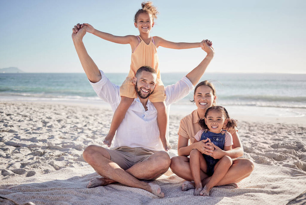 Family, parents and children bonding on beach in fun, play and happy picnic by sea or ocean in Colombia. Portrait, smile and relax man and woman with girls, kids and security trust on summer holiday. - Photo, Image