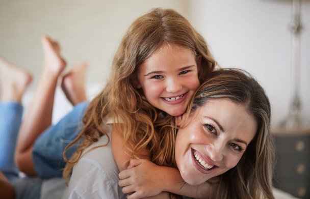 Relax, hug and portrait of mother with child in New Zealand family home enjoy bonding together. Care, love and happy mother smiling with young daughter in house on weekend for leisure time - Photo, Image