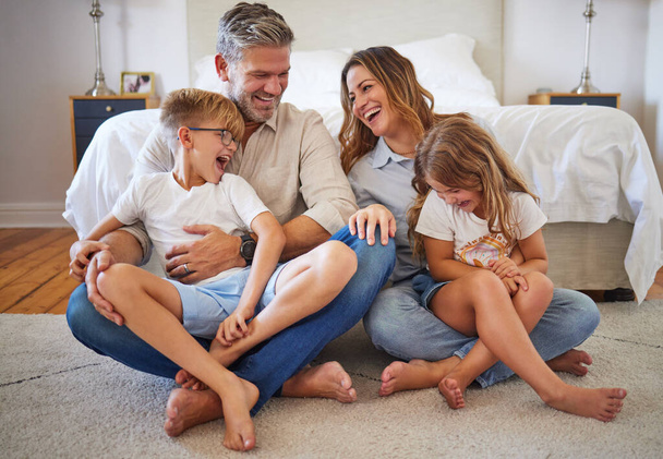 Big family, happy and smile with quality time at home in a bedroom with children. Happiness of mother, man and kids laughing at a funny joke on the house floor together with joy and parent love. - 写真・画像