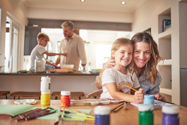 Η μητέρα και το παιδί ζωγραφική στο οικογενειακό πορτρέτο σπίτι με τον πατέρα και το παιδί μαγείρεμα μαζί για την ανάπτυξη δημιουργικών δεξιοτήτων και τη μάθηση. Γονείς ή άτομα που διδάσκουν διασκεδαστική δραστηριότητα σε εξοχικές κατοικίες. - Φωτογραφία, εικόνα