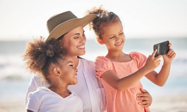Selfie, beach and mom with kids on family vacation, summer travel and relaxing fun in Colombia. Happy mothers day, smile girl children and taking photo on phone for love, sunshine holiday and freedom. - Photo, Image