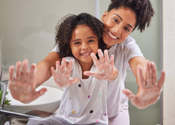 Woman, child and washing hands in bathroom, cleaning to prevent germs and virus in home. Soap, water and hygiene, girl and mom from Brazil. Teaching, learning a clean morning routine and happy family. - Zdjęcie, obraz