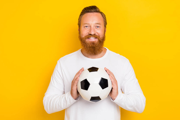 Photo of satisfied glad person arms hold football toothy smile isolated on yellow color background. - Foto, Bild