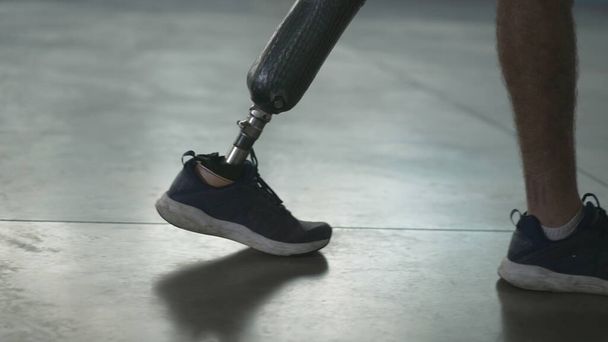 Pessoa com deficiência a andar com a perna protética dentro de casa. Homem amputado caminha com perna protética - Foto, Imagem