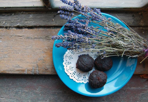Tumma suklaa tryffelit laventeli jälkiruoka lautasella ja puinen tausta
 - Valokuva, kuva