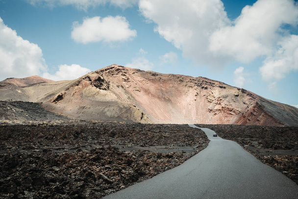 Droga asfaltowa w wulkanicznym krajobrazie Parku Narodowego Timanfaya, Lanzarote, Wyspy Kanaryjskie, Hiszpania - Zdjęcie, obraz