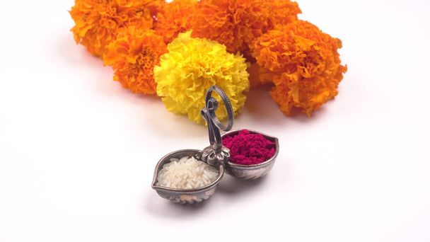 marigold λουλούδια, που διοργανώνονται με ρύζι και kumkum σε λευκό φόντο - Φωτογραφία, εικόνα