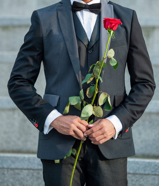 love rendezvous concept. cropped view of tuxedo man with love rose. flower rose for love day. - Fotó, kép