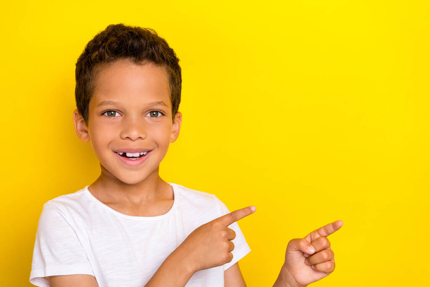 Close up photo of cute boy two arm direct empty space satisfied new outfit sale discount shopping isolated on yellow color background. - Foto, imagen