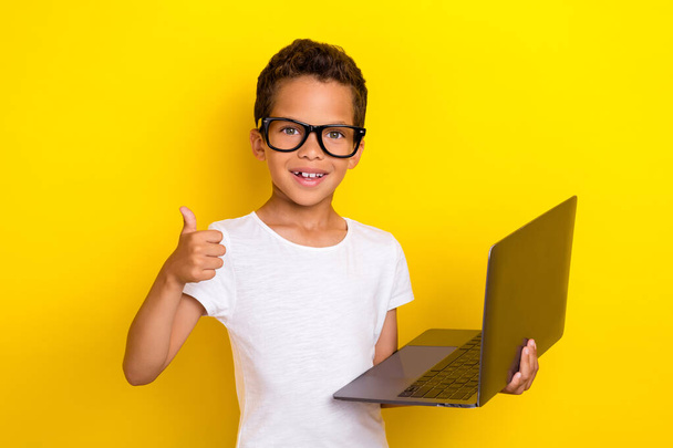 Photo of little man pupil boy model glasses hold netbook enjoy remote distance online education study lesson isolated on yellow background. - Foto, immagini