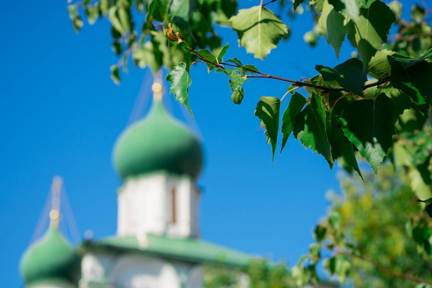 Tserkov 'Maksima Blazhennogo, kerk met uienkoepels achter de boombladeren. Moskou, Rusland - Foto, afbeelding