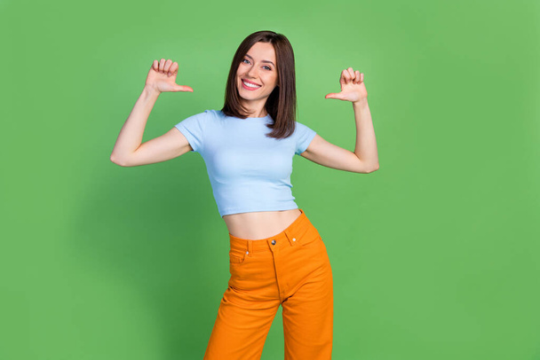 Photo of cheerful adorable lady indicate thumb fingers self herself isolated on green color background. - Fotoğraf, Görsel