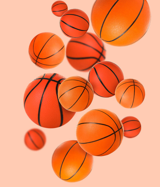 Летающие баскетбольные мячи на бежевом фоне - Фото, изображение