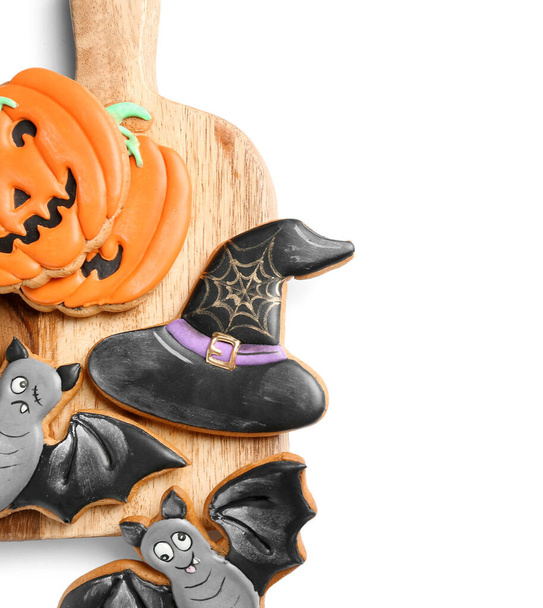 Board with tasty Halloween cookies on white background - Photo, Image