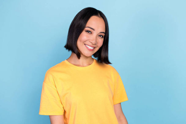 Portrait of nice positive gorgeous girl with bob hairstyle dressed yellow t-shirt smiling at camera isolated on blue color background. - Fotografie, Obrázek