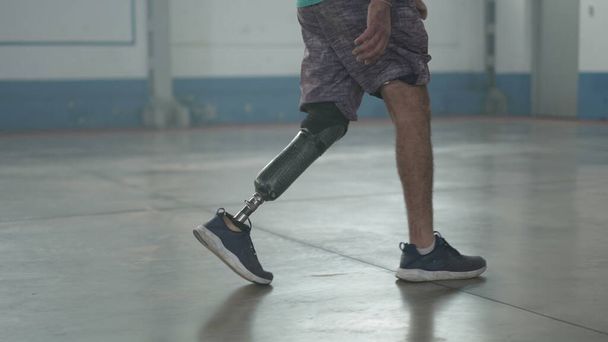 Disabled person walking with his prosthetic leg indoors. Amputee man walks with prosthetic leg - Foto, imagen