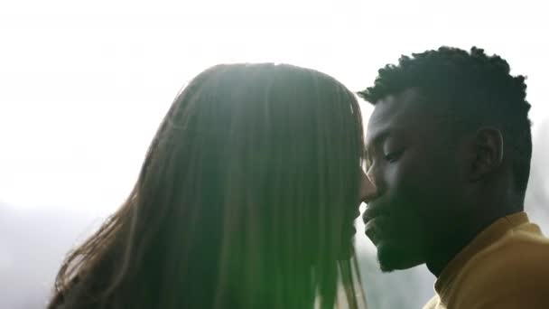 Joven pareja interracial besándose afuera. negro hombre con blanco novia beso diversidad concepto - Metraje, vídeo