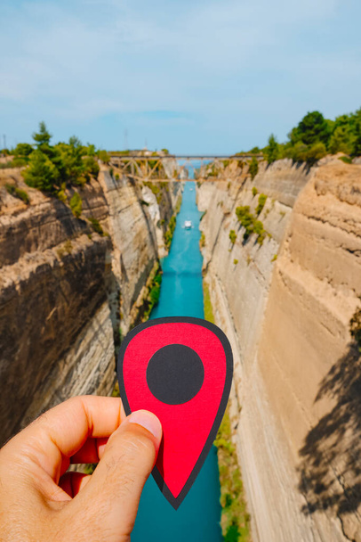 closeup of the hand of a man with a red marker in his hand at the Corinth Canal, from Isthmia, Greece, in a summer day - 写真・画像