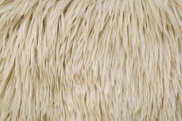 Schapen huid textuur. Schapenvacht achtergrond. Witte wol textuur achtergrond. Natuurlijke pluizige bont schapenwol huidtextuur. Beige kleur tapijt. - Foto, afbeelding