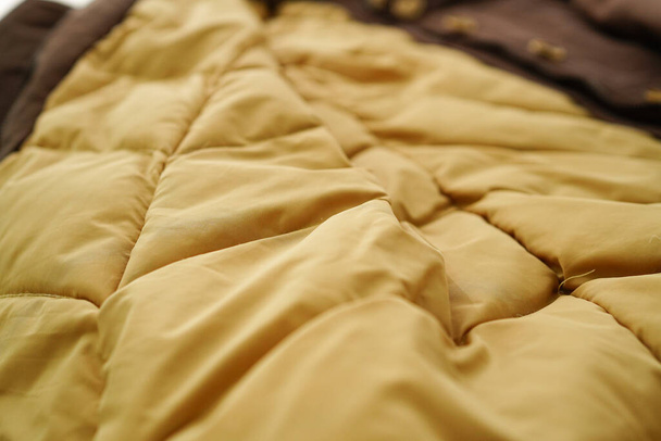 Gros plan sur la courtepointe intérieure du manteau gonflable pour femme avec capuche en fourrure  - Photo, image