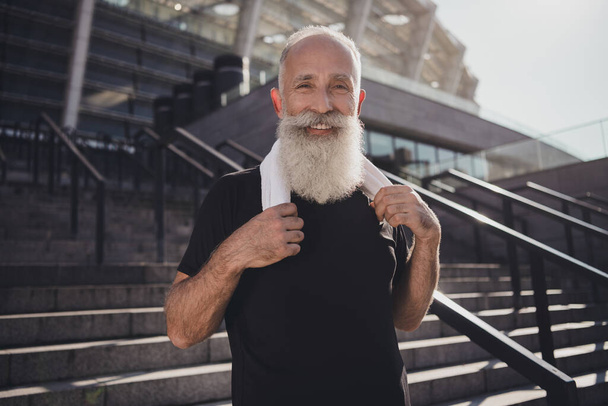 Photo of funny charming retired man black sportswear finishing successful training smiling outside urban city street. - 写真・画像