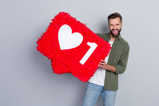 Zdjęcie radujący facet blogger pokazać czerwony serce kształt papieru nowy kanał vlog izolowane na szarym tle koloru. - Zdjęcie, obraz