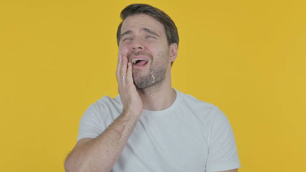 Casual Young Man having Toothache on Yellow Background - Photo, Image