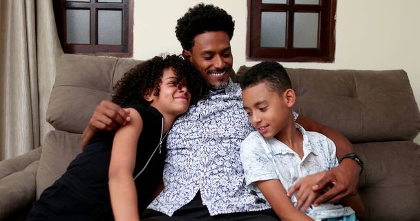 African father embracing daughter and son together at couch living-room - Photo, Image