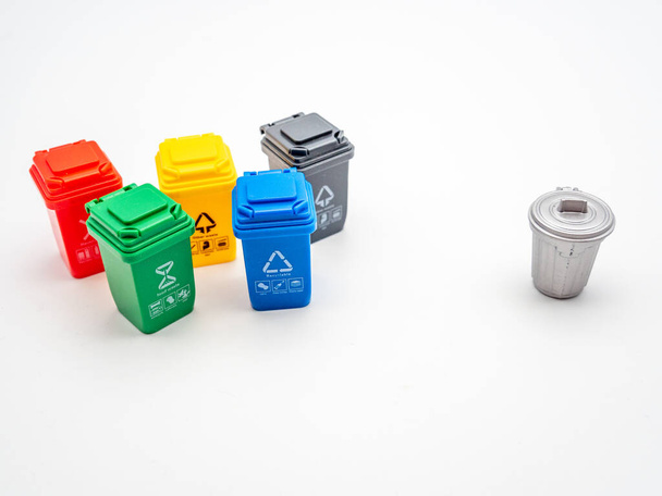 varios contenedores de reciclaje de colores para diferentes tipos de basura en comparación con la papelera tradicional en blanco, reciclaje concepto de protección del medio ambiente - Foto, imagen