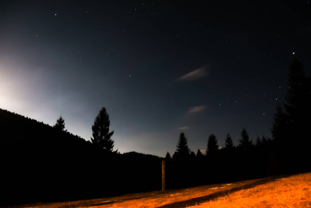 Горный пейзаж ночью со звездами и ясным небом - Фото, изображение
