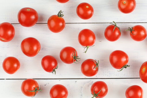 Κόκκινη ντομάτα κεράσι σε λευκό τραπέζι. Ιστορικό ή υφή με ντομάτες - Φωτογραφία, εικόνα