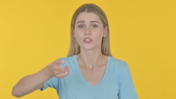 Θυμωμένη περιστασιακή νεαρή γυναίκα που μαλώνει για το κίτρινο φόντο  - Πλάνα, βίντεο