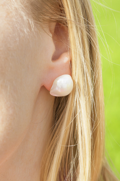 oreja de mujer con un pendiente de perla
 - Foto, imagen