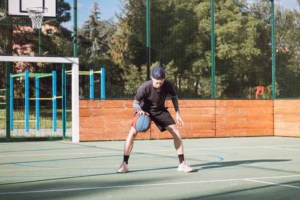 Fiatal tehetség gyakorolja csöpög a kosárlabda a lába alatt, és javítja a kéz, a test és a láb koordináció. Kosárlabda meccs. Megtanulni a trükköt, a megtévesztést. - Fotó, kép