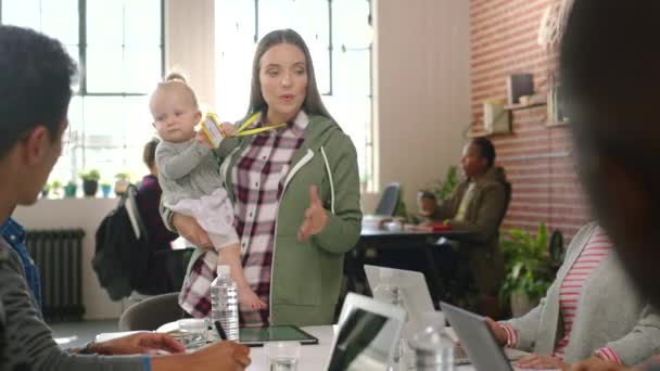 Mom with baby, manager on tablet and presentation with team at office startup meeting. Motherhood, parenting and female leader with kid managing employees, coaching or training with group on tech - Footage, Video