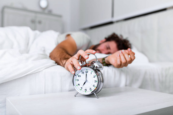 Daha uzun uyu. Sağlık hizmeti konsepti. Uykunun aşamaları. Alarm çaldığı için mutsuz bir adam uyandı. Uyuyor olsan da hiç uyumamış gibi hissedebilirsin.. - Fotoğraf, Görsel