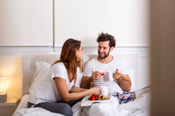 Романтичний сніданок у ліжку чоловік готується до своєї жінки, вона була дуже щаслива, молода красива пара в ліжку сніданок і кава в ліжку
 - Фото, зображення