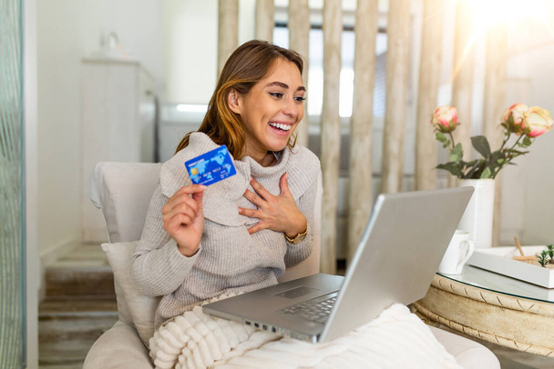 Красива жінка купує в Інтернеті з кредитною карткою. жінка тримає кредитну картку і використовує ноутбук. Інтернет концепція покупки красивої жінки покупки з дому
 - Фото, зображення
