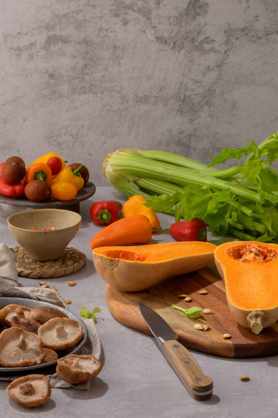 Autumn vegetables arranged on a kitchen worktop while preparing a pumpkin soup. - Фото, изображение