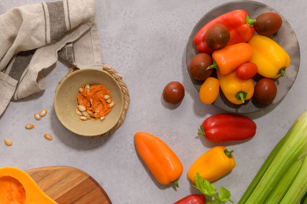 Осенние овощи расположены на кухонном столе во время приготовления тыквенного супа. - Фото, изображение