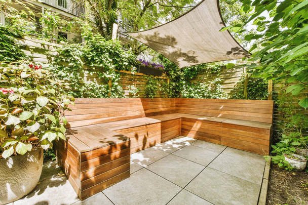 Neat paved patio with sitting area and small garden near wooden fence - Foto, Imagem